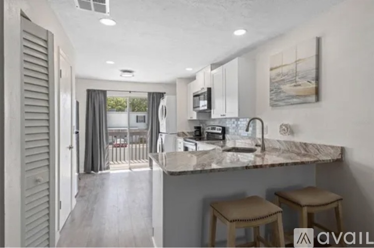 A kitchen with a marble countertop and bar stools.