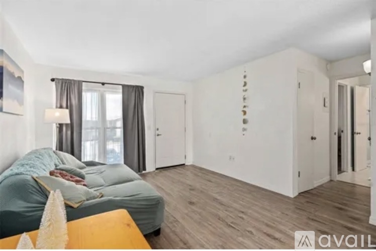 A bedroom with a bed, a couch, and a window with curtains.