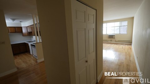 A BEALPROPERTIES sign is on a door in a room with a kitchen in the background.