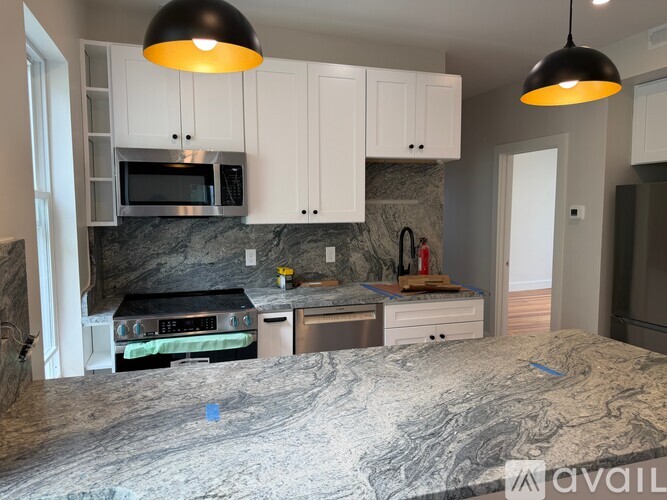 A kitchen with granite countertops and white cabinets.