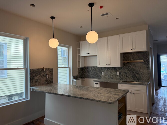 A kitchen with granite countertops and white cabinets.