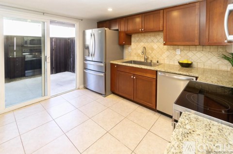 A kitchen with wooden cabinets and granite countertops.