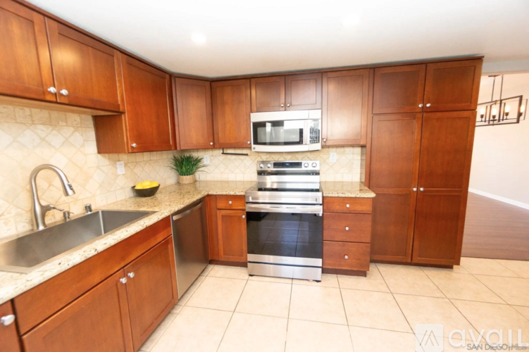 A kitchen with wooden cabinets and a stainless steel sink.