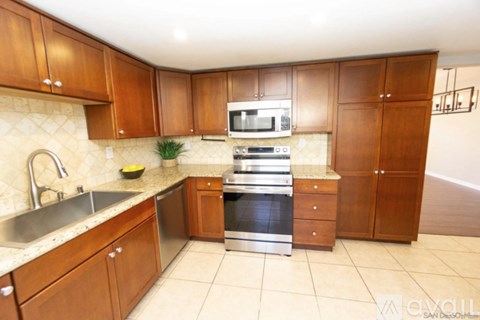 A kitchen with wooden cabinets and a stainless steel sink.