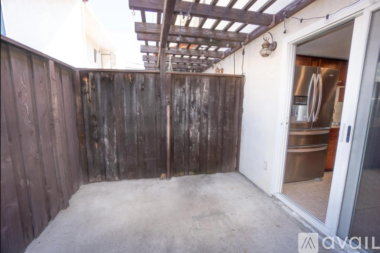 A room with a wooden wall and a refrigerator in the background.