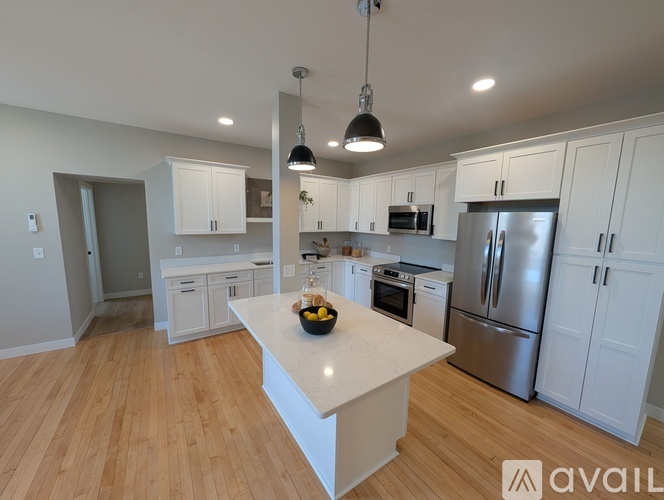 A kitchen with white cabinets and a central island.