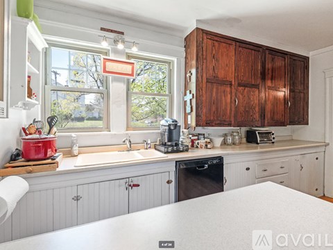 A kitchen with wooden cabinets and a window.