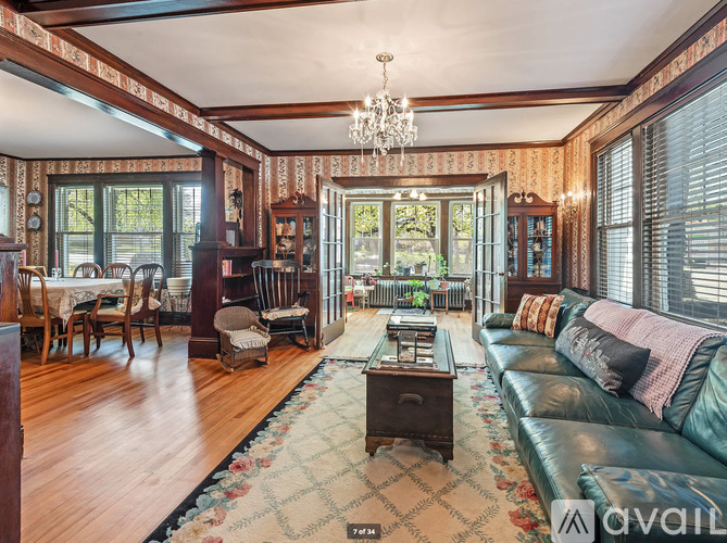 A living room with a couch, chairs, and a chandelier.