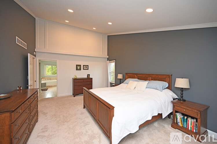 A bedroom with a large bed and a dresser.