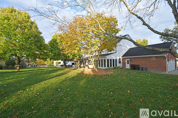 A house with a lawn and trees in front of it.