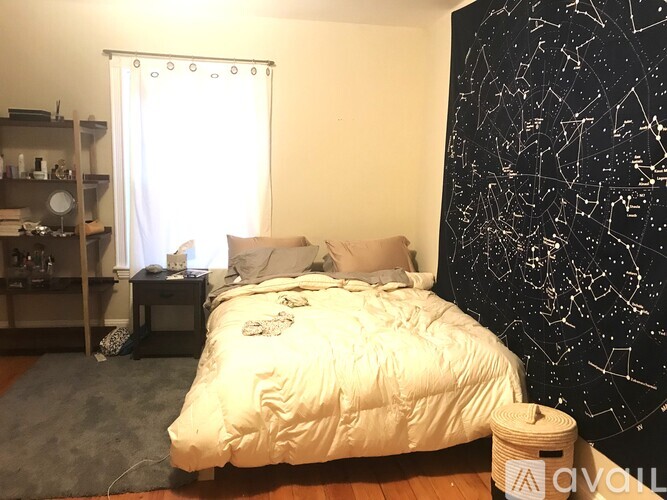 A bedroom with a large bed and a wallpapered wall.