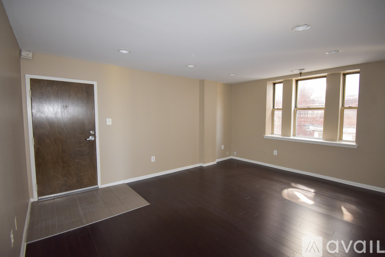 A room with a brown door and a window with white frames.