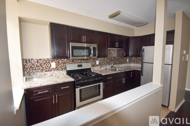 A kitchen with brown cabinets and a white counter.
