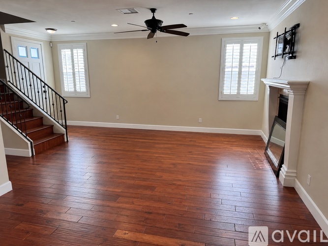 A living room with hardwood floors and a fireplace.