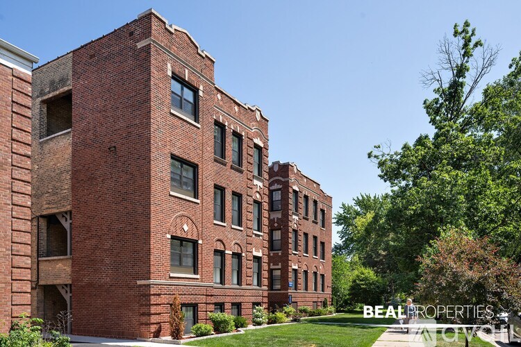 A red brick building with trees in front of it.