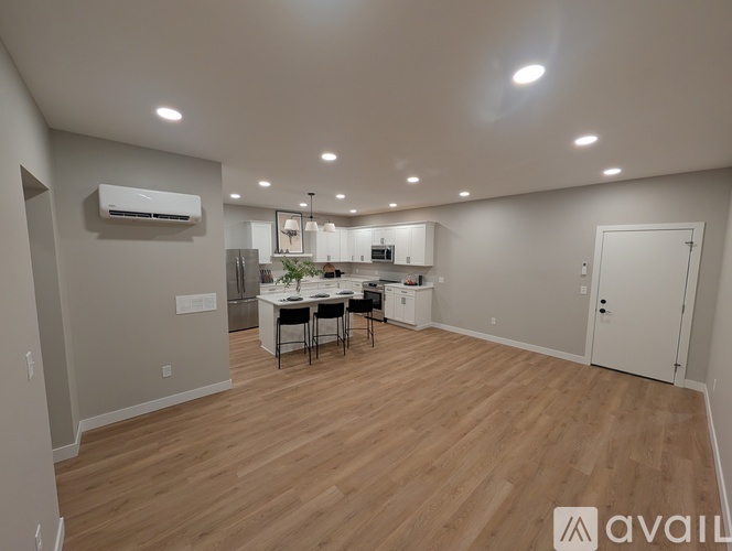 A well-lit, spacious kitchen and dining area with wooden flooring and modern appliances.