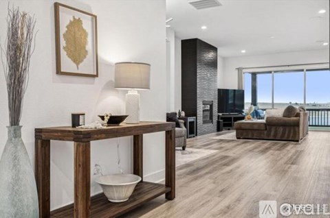 A modern living room with a wooden table and a large window.