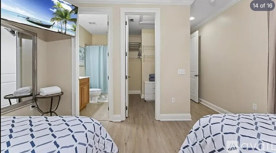 A bedroom with two beds and a television.