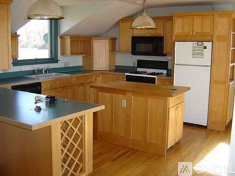 A kitchen with wooden cabinets and a white refrigerator.