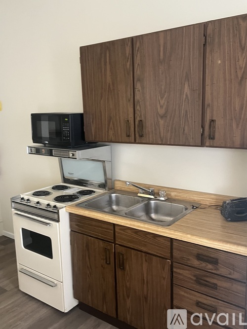 A kitchen with a white stove and wooden cabinets.