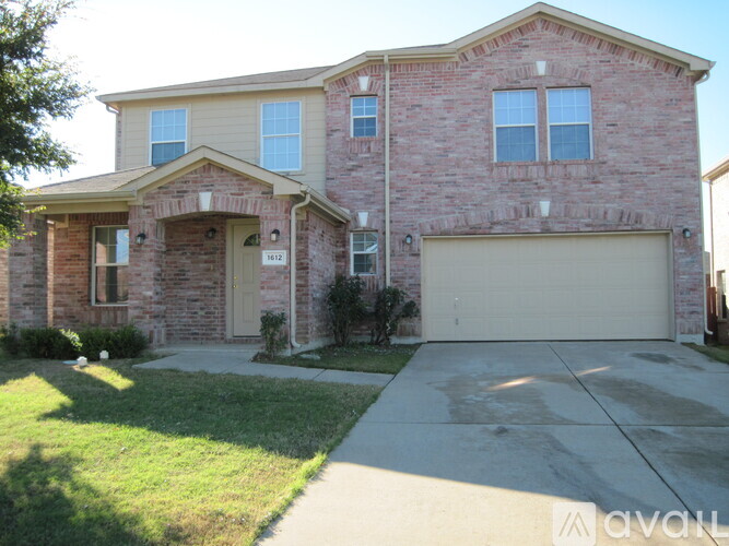 A brick house with a garage door and a driveway.