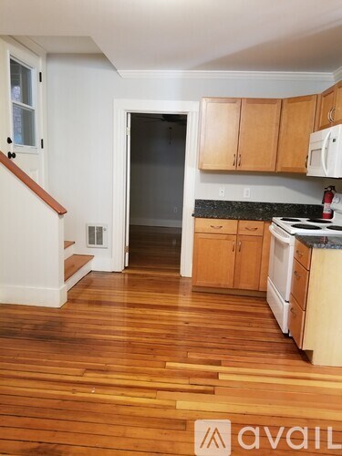 A kitchen with wooden floors and white walls.