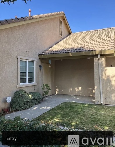 A house with a brown roof and a beige wall with a window and a door.