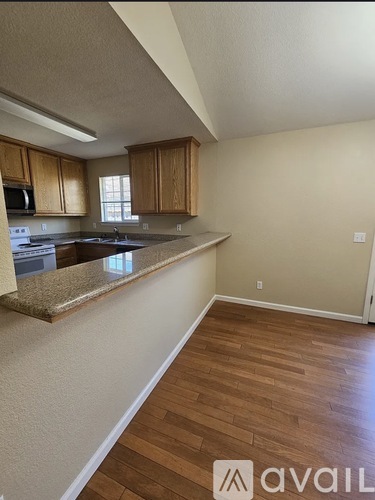 A kitchen with wooden cabinets and a granite countertop.