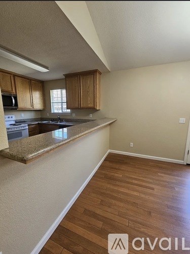 A kitchen with wooden cabinets and a granite countertop.