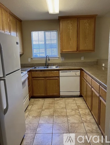 A kitchen with a white refrigerator and wooden cabinets.