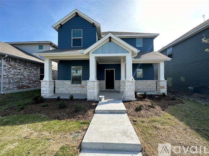 A blue house with a white walkway leading to the front door.