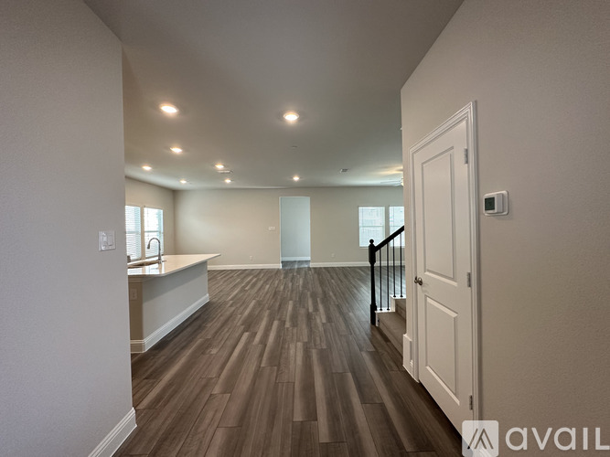 A spacious room with wooden flooring and a white door.