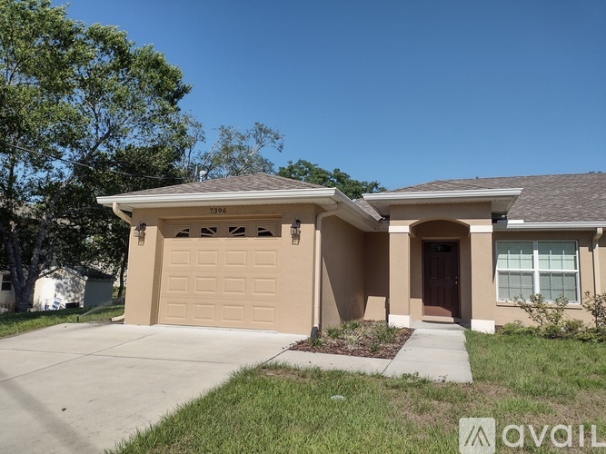 A beige house with a brown roof and a brown door.
