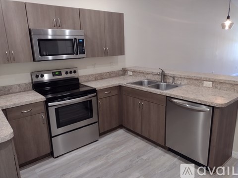 A kitchen with a stove, oven, microwave, and sink.