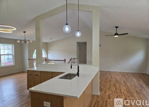 A kitchen with a white countertop and wooden cabinets is available for rent.