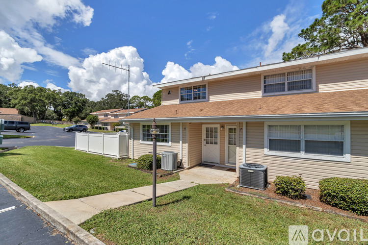 A house with a brown roof and a white fence is for sale.