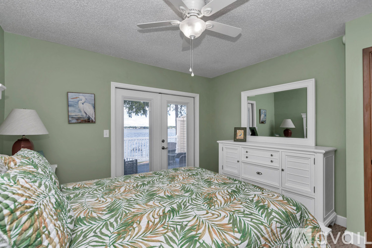 A bedroom with two beds and a ceiling fan.