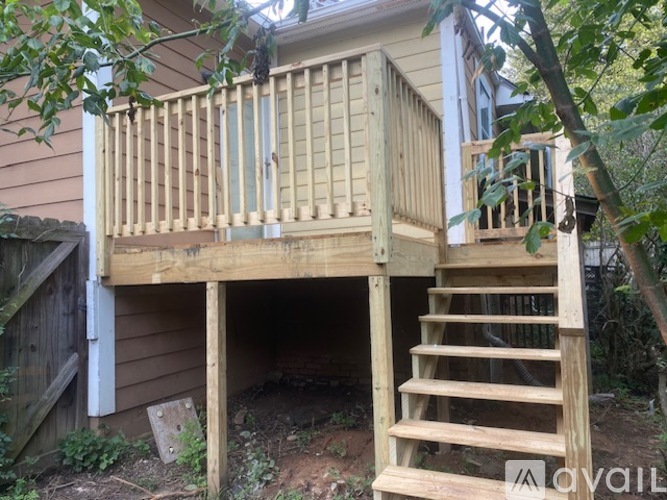 A wooden deck with stairs leading to a basement entrance.