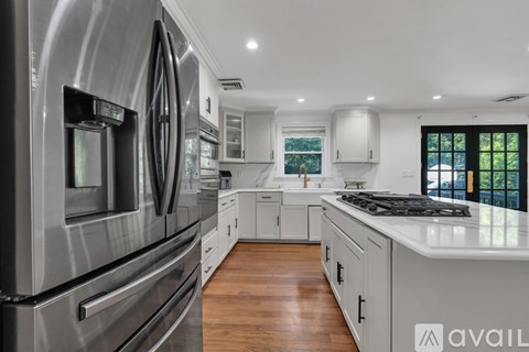 A modern kitchen with stainless steel appliances and wooden floors.