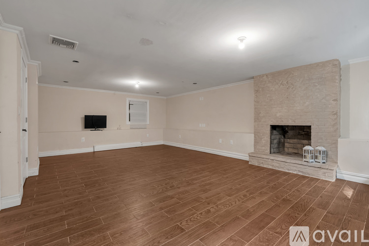A living room with a fireplace and a flat screen TV.