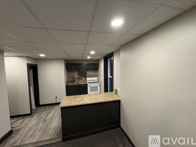 A reception area with a granite counter and a view of a kitchen in the background.
