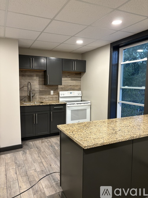 A kitchen with granite countertops and a washer and dryer built in.