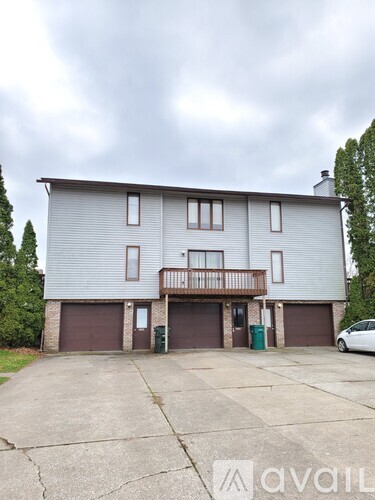 A two-story house with a garage and a balcony.
