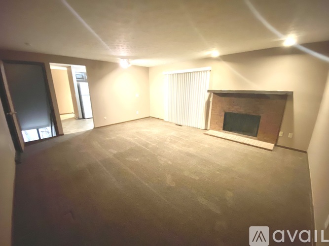 A spacious room with a fireplace and a window.