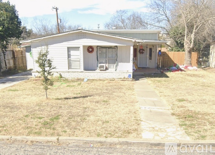 A house with a white front door and a wreath on it.