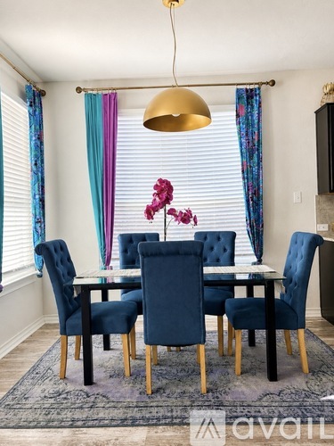 A dining room with a table and chairs.