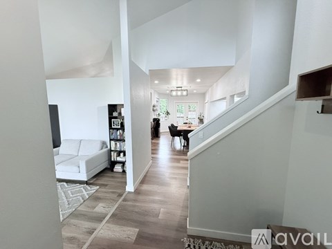 A living room with a white couch and a wooden floor.
