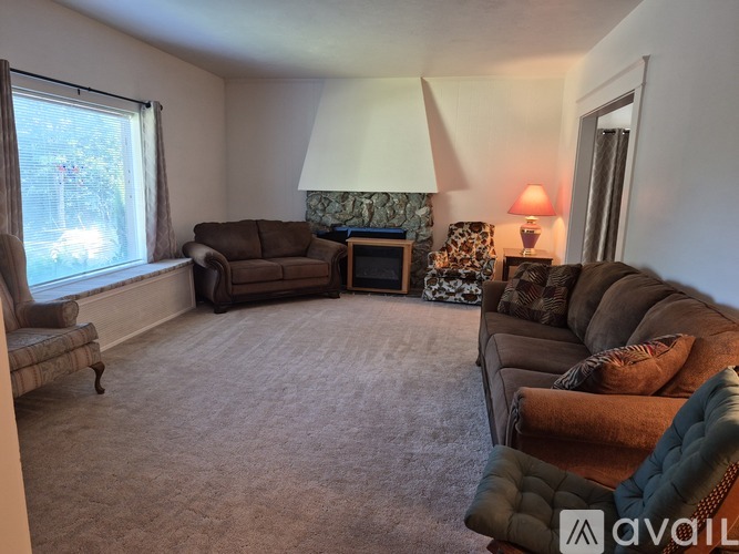 A living room with a brown couch, a chair, and a lamp.