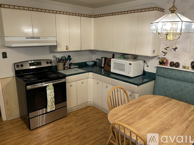 A kitchen with a wooden table and chairs.