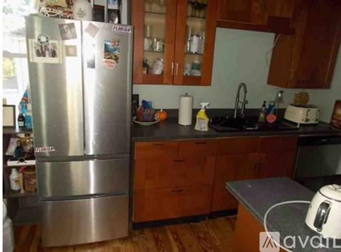 A kitchen with a refrigerator, sink, and toaster.